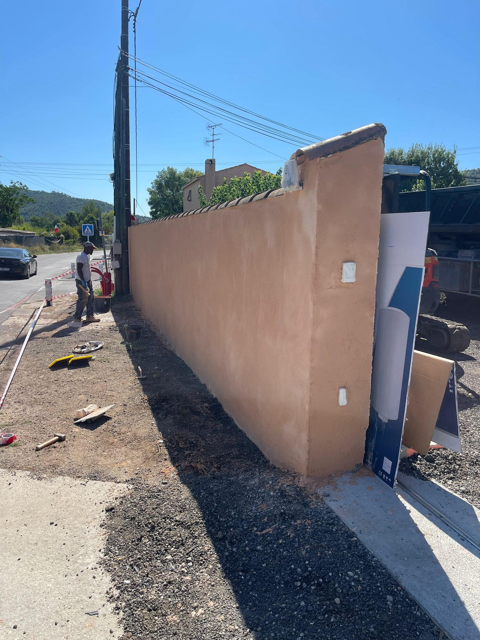 Mur de façade après ravalement : enduit teinté ocre, propre et net